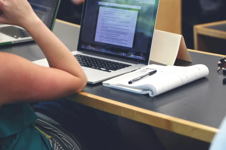 Student preparing for an accounting job interview on a laptop with notes open beside them