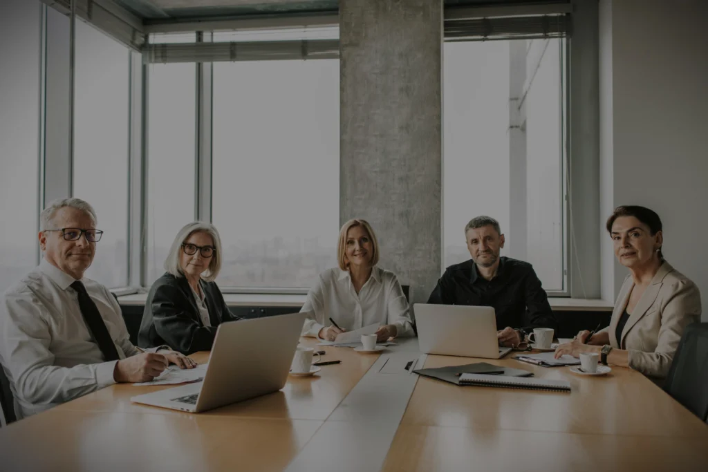 Executive hiring panel meeting in a GTA boardroom with laptops