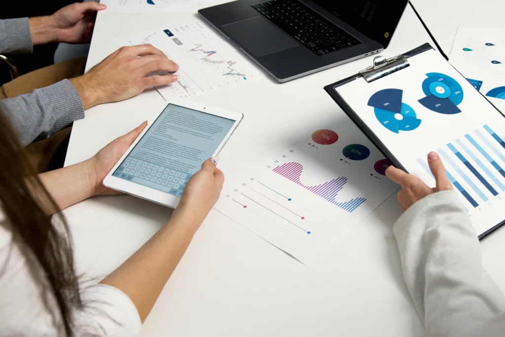 Finance professionals analyzing salary data and hiring trends with reports and charts.