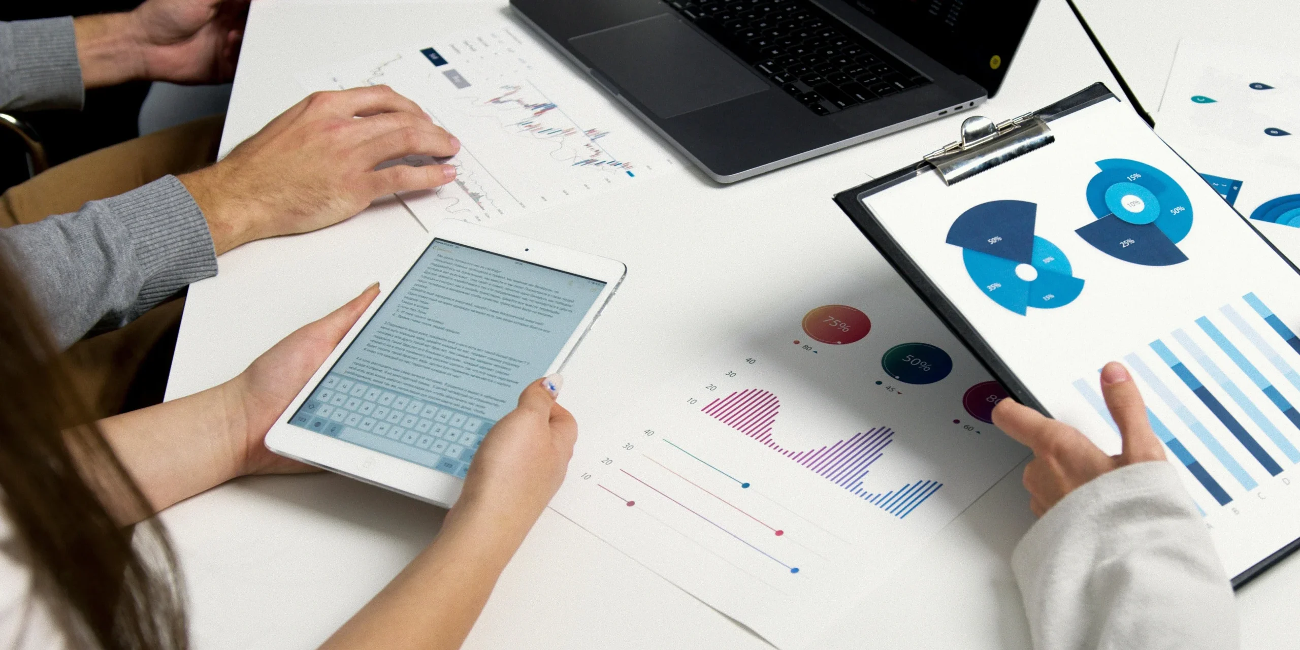 Finance professionals analyzing salary data and hiring trends with reports and charts.